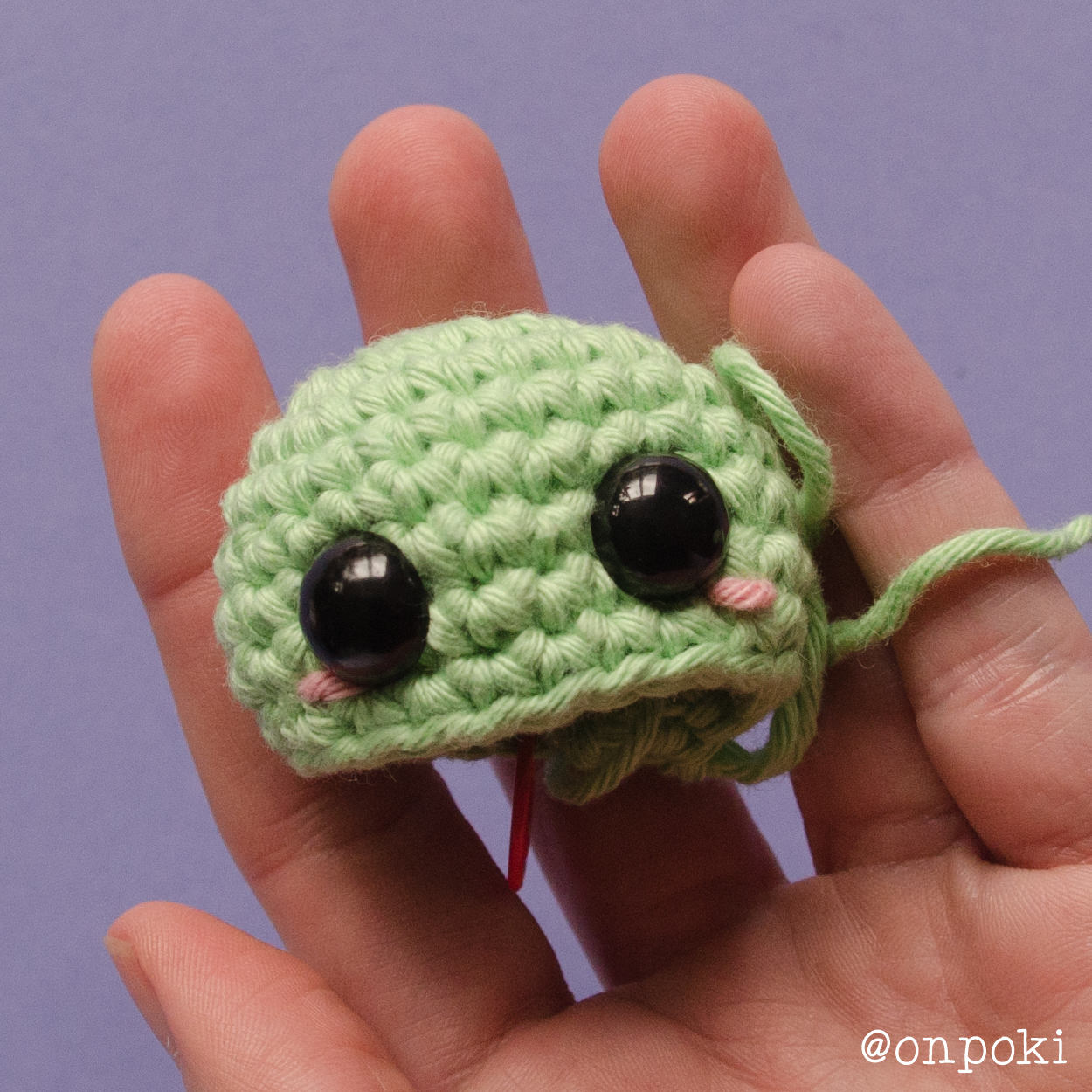 Safety eyes and blush placement on Grogu’s face before sewing